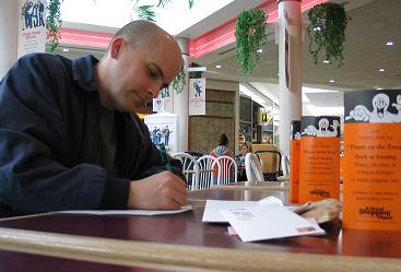 Brett writing letters in the Fayette Mall food court